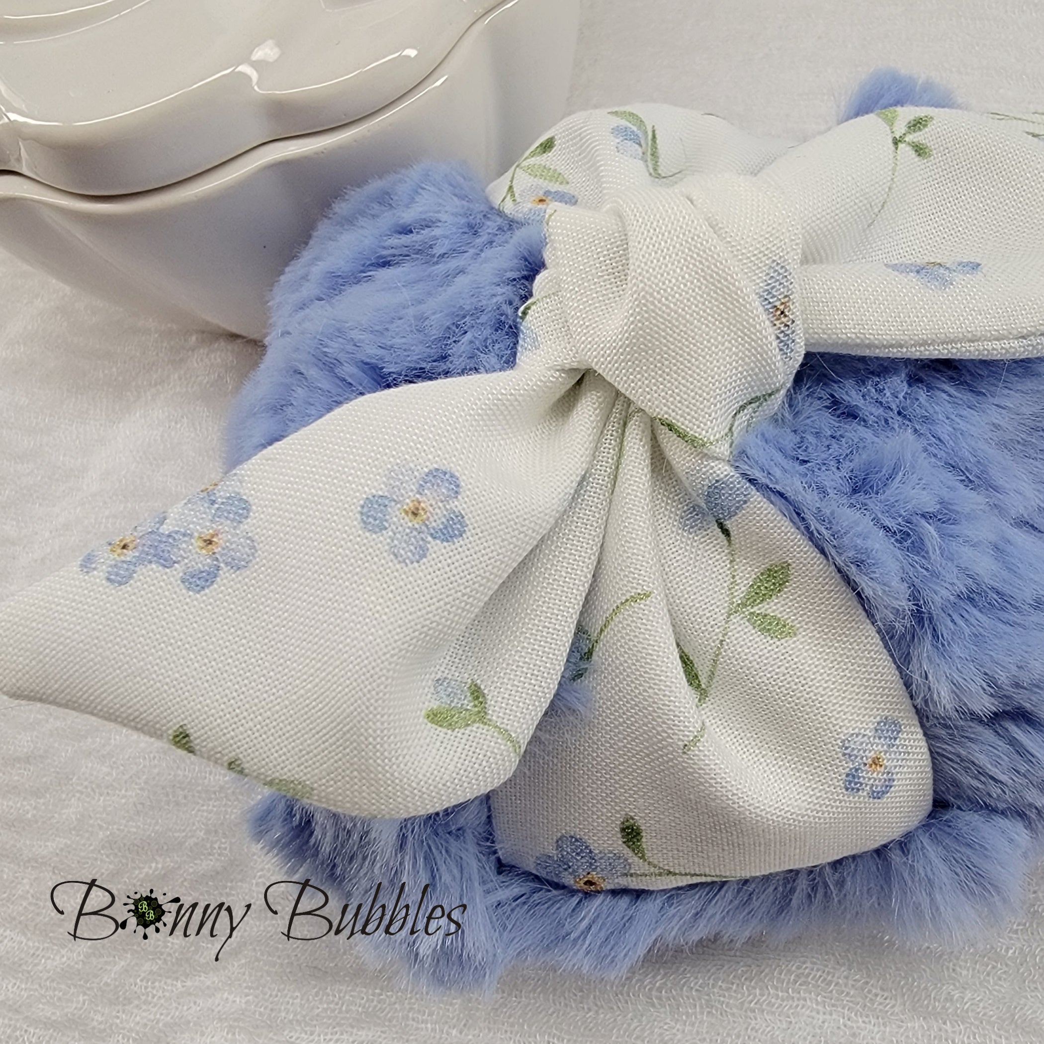 soft blue body powder puff with tiny blue flowers. Measures 4 inches across.